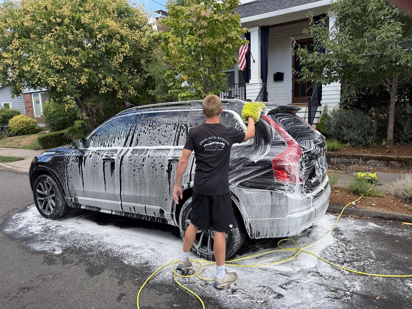 Hand washing a foam-covered SUV in NE Portland