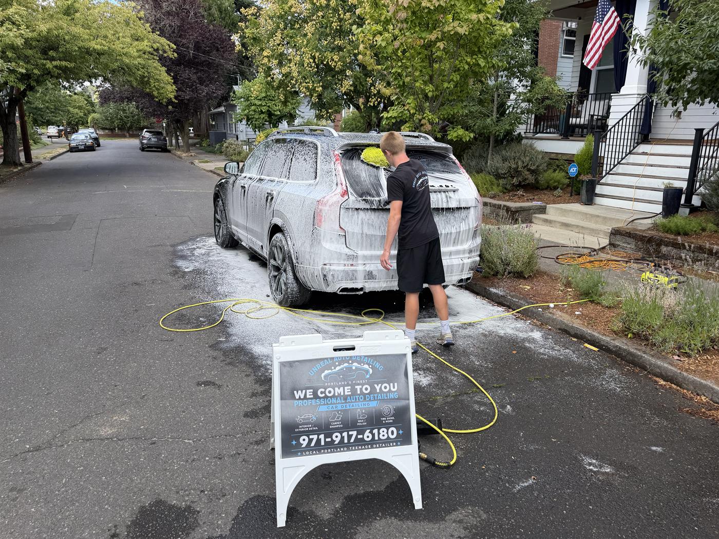 Unreal Auto Detailing set up on a Grant Park street with the sign out front